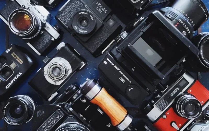 a table topped with lots of different types of cameras