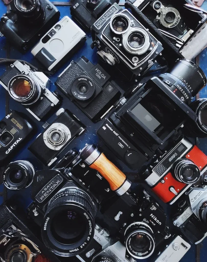 a table topped with lots of different types of cameras