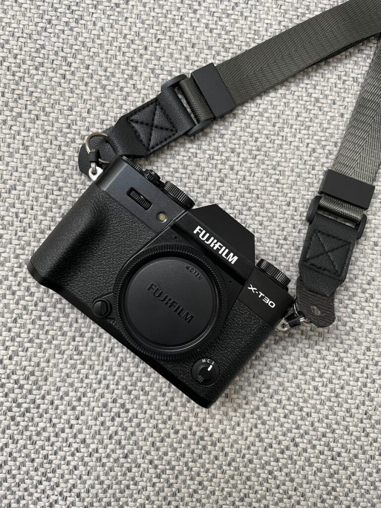 a black camera sitting on top of a gray blanket