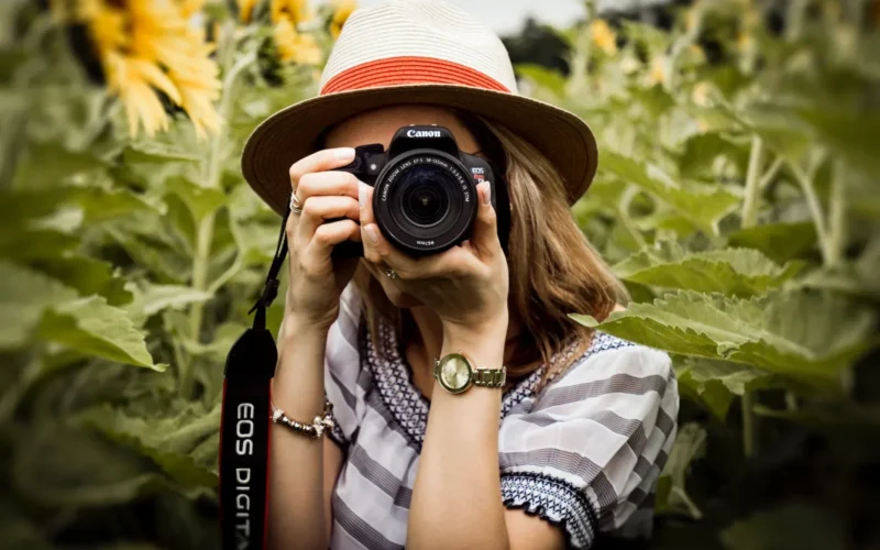 selective focus photography of woman holding dslr camera