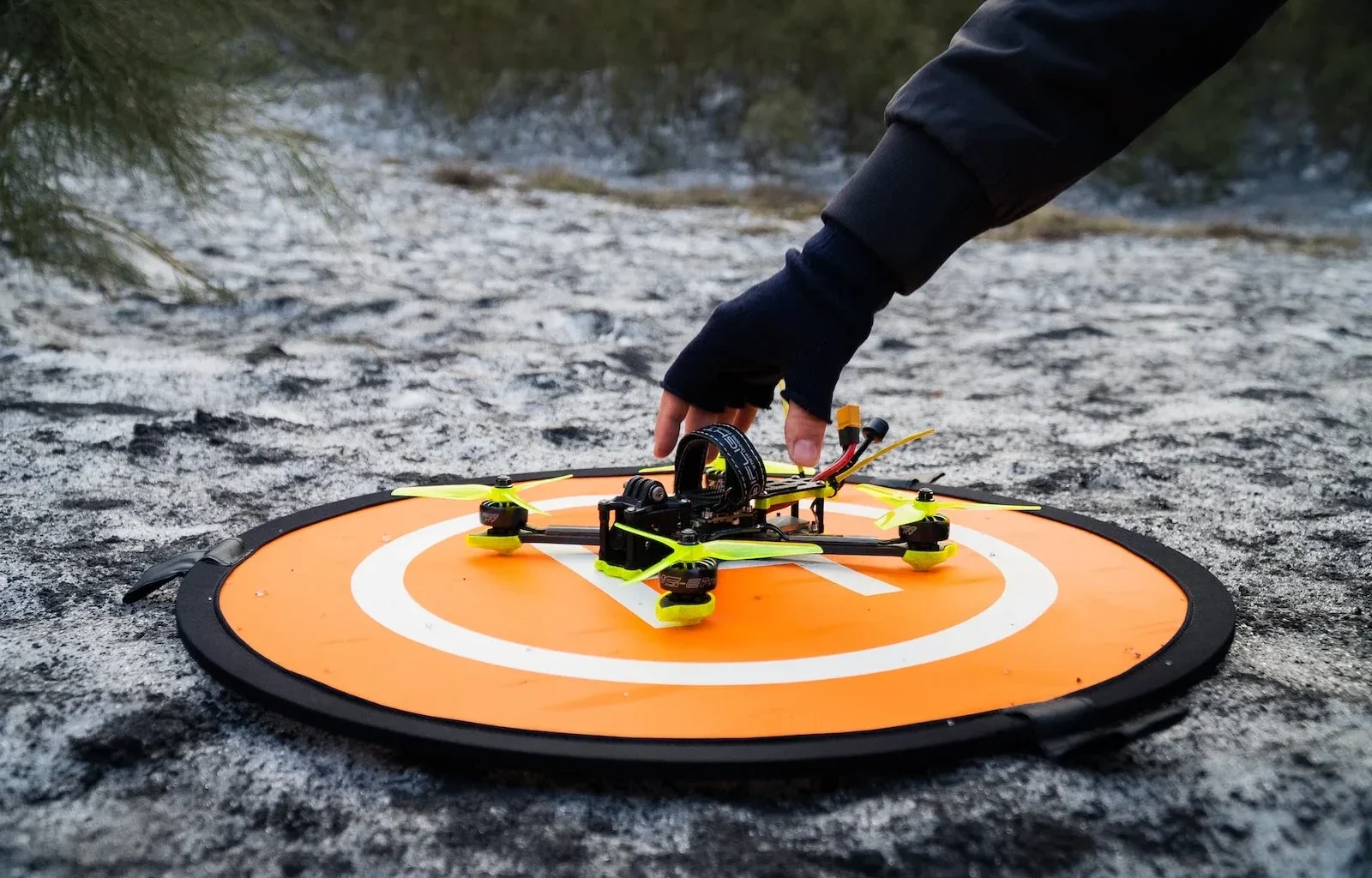a person holding a remote control helicopter on top of a field