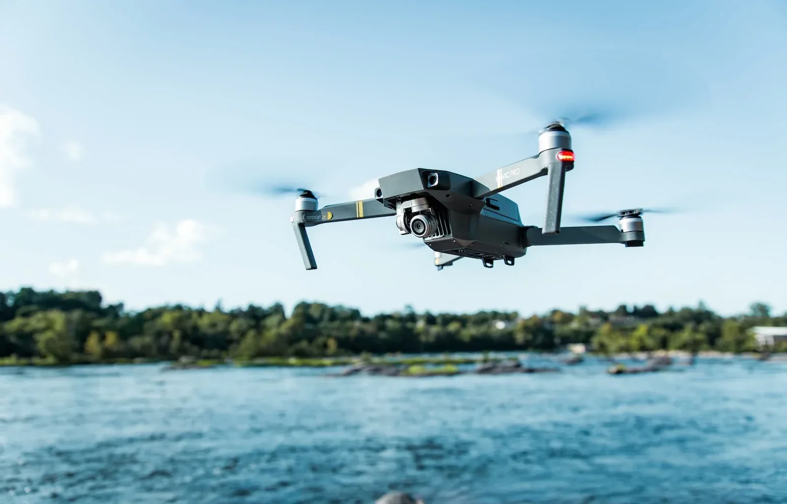 black DJI Mavi quadcopter near body of water