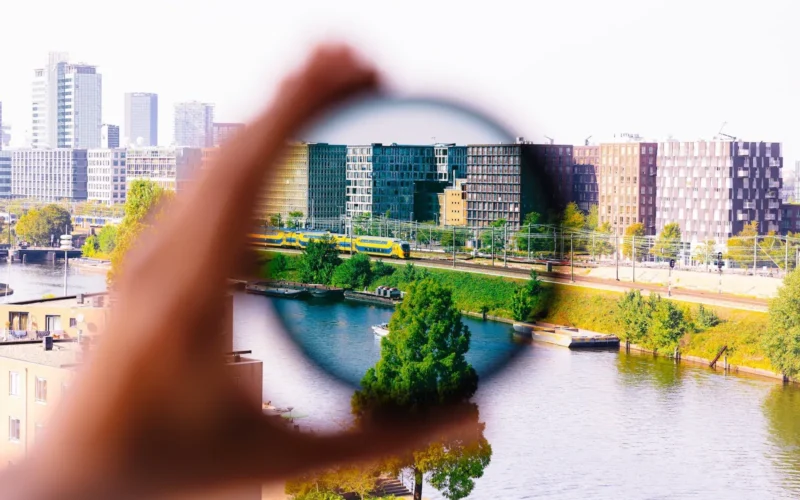 a person holding a magnifying glass over a river