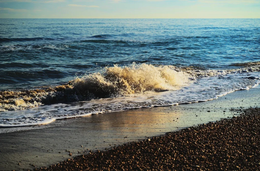 ocean waves crashing on shore during daytime