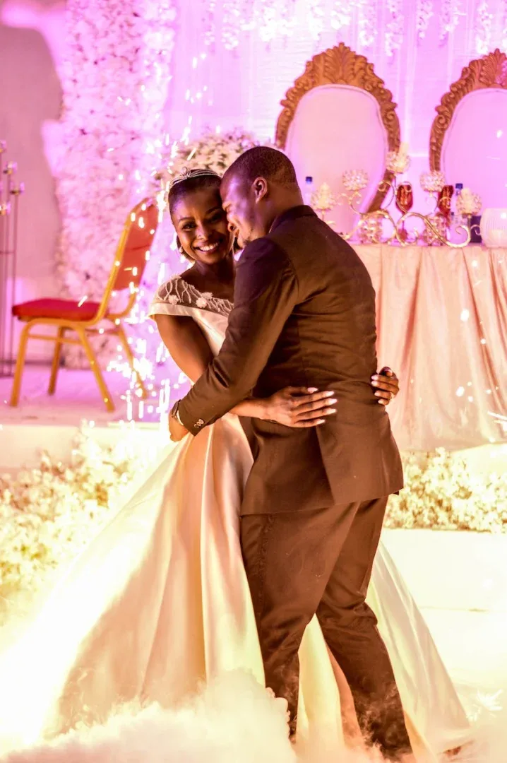 man in black suit and woman in white wedding gown dancing